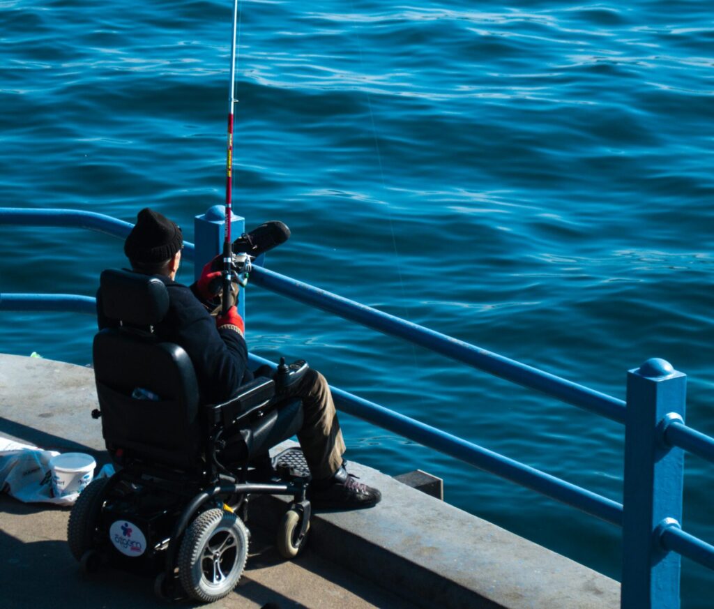 pexels-photo-15770521-15770521 A person in a wheelchair fishing on a pier in Istanbul, Türkiye. Calm sea view.